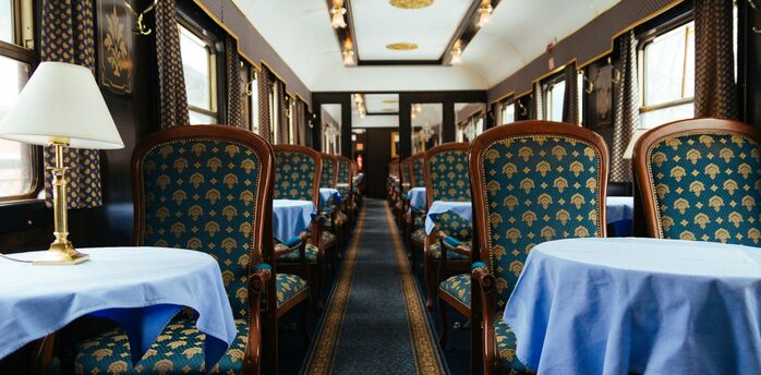 Elegant train dining car with blue upholstered chairs