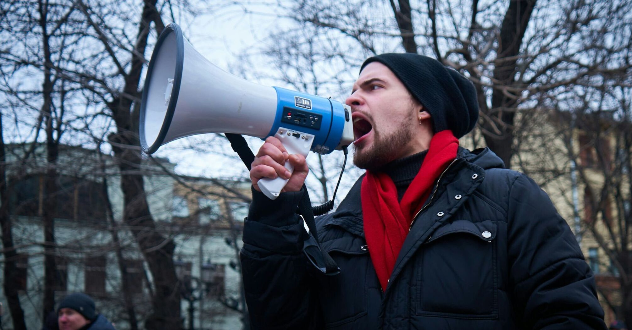 Man speaking through a megaphone at a protest