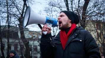 Man speaking through a megaphone at a protest
