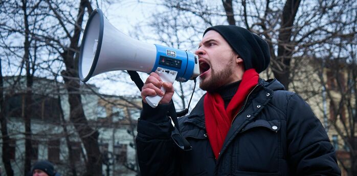 Man speaking through a megaphone at a protest
