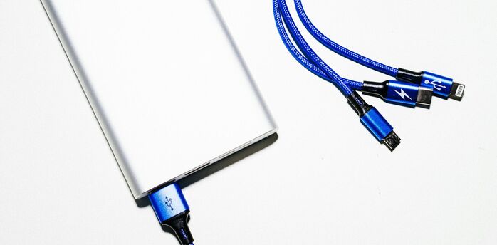 Silver power bank with blue charging cables