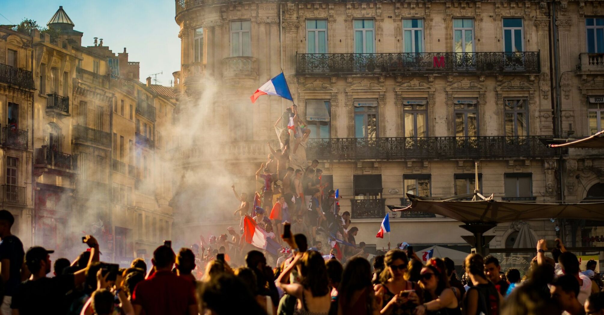 Crowd waving French flags amid smoke