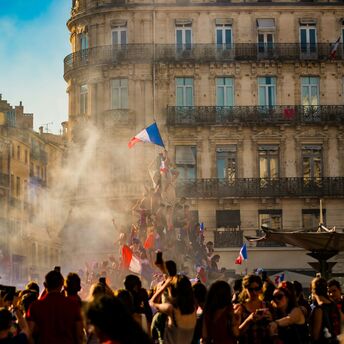 Crowd waving French flags amid smoke
