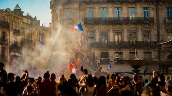 Crowd waving French flags amid smoke