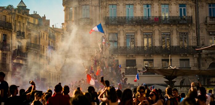 Crowd waving French flags amid smoke