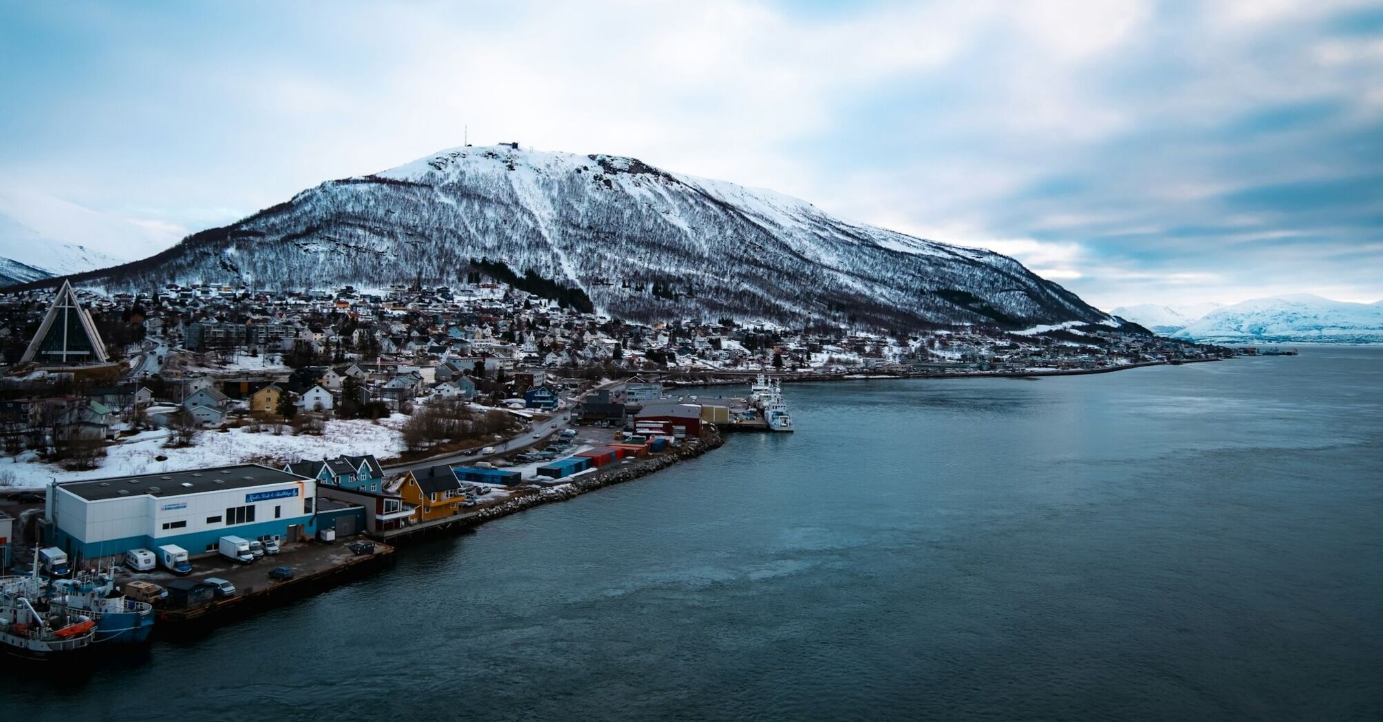 Snow-covered mountain overlooking Tromsø's waterfront and harbour