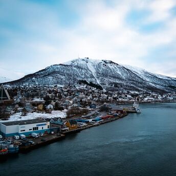 Snow-covered mountain overlooking Tromsø's waterfront and harbour