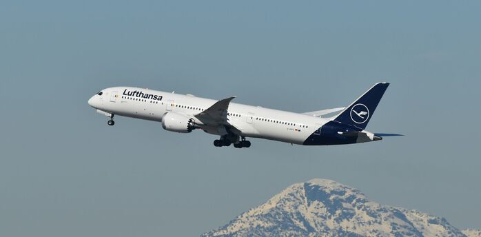 Lufthansa passenger jet flying above a snow-covered mountain
