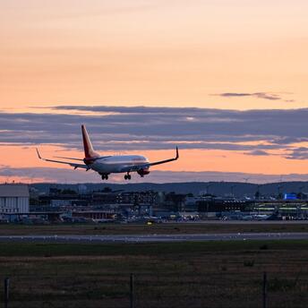 Passenger aircraft approaching an airport runway at sunset