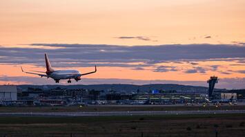 Passenger aircraft approaching an airport runway at sunset
