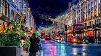 Red double-decker buses beneath Christmas angel lights on London's Regent Street