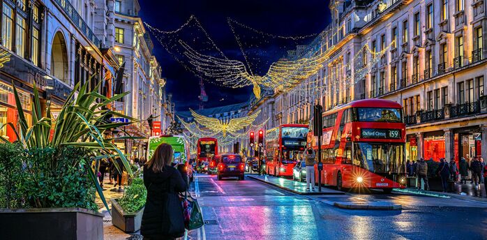 Red double-decker buses beneath Christmas angel lights on London's Regent Street