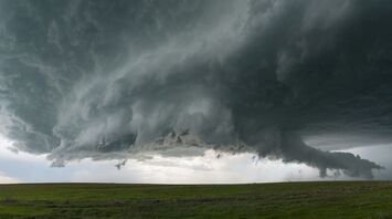 Dark storm clouds hanging over an open grassy field