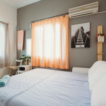 Bright holiday rental bedroom with a made bed and folded towels