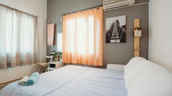 Bright holiday rental bedroom with a made bed and folded towels