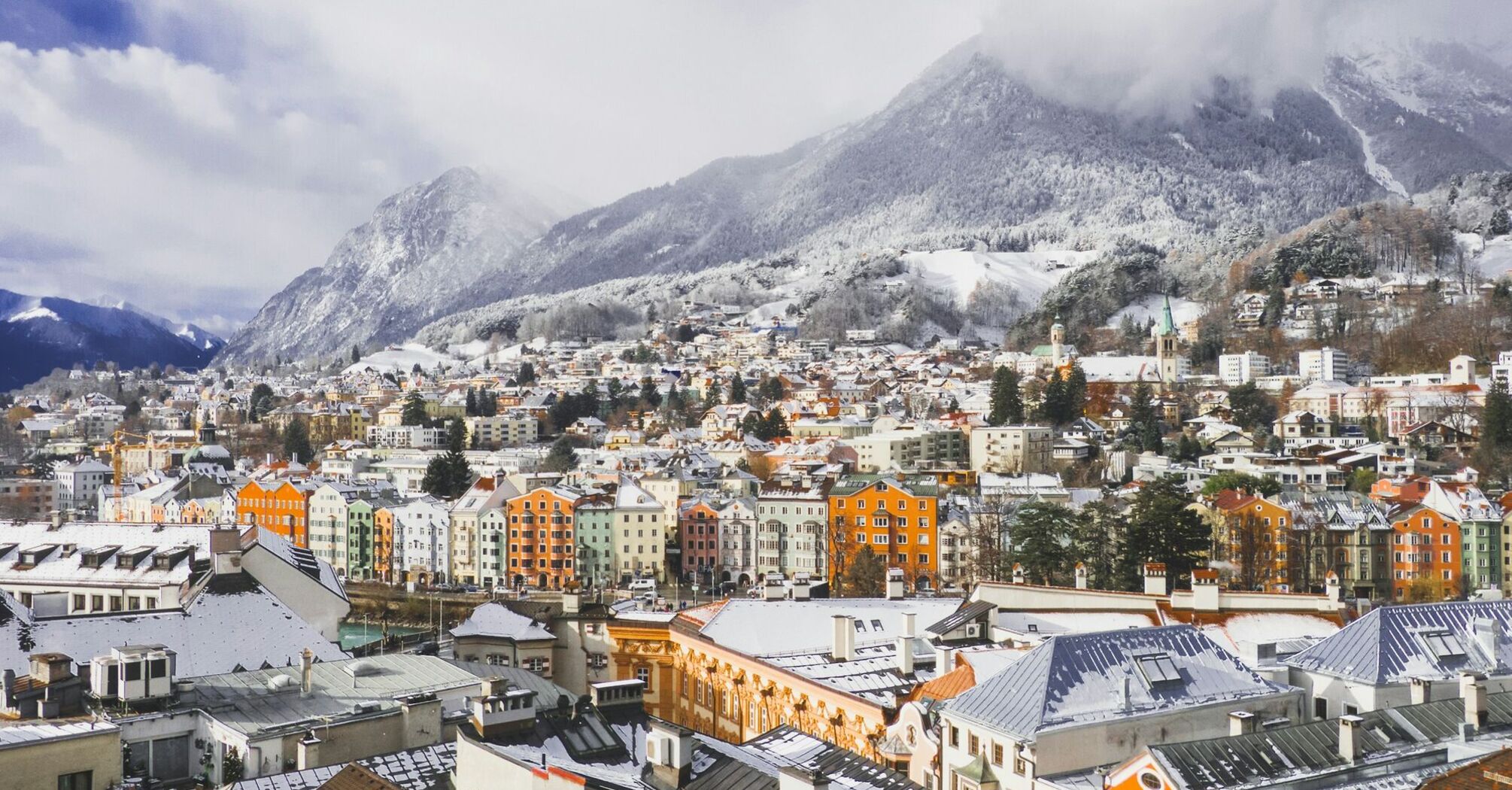 Snow-covered rooftops of Innsbruck beneath the Austrian Alps