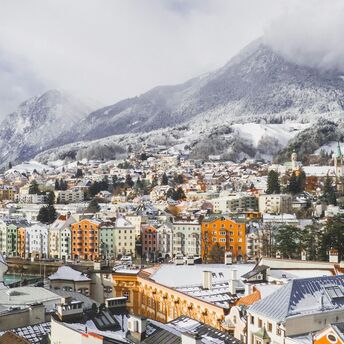 Snow-covered rooftops of Innsbruck beneath the Austrian Alps