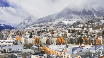 Snow-covered rooftops of Innsbruck beneath the Austrian Alps