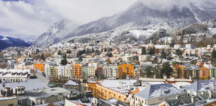 Snow-covered rooftops of Innsbruck beneath the Austrian Alps