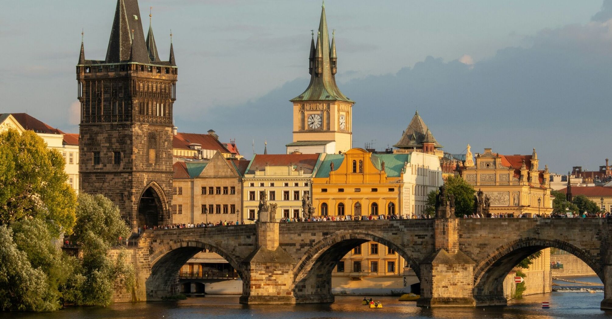Charles Bridge spanning the Vltava River in Prague with historic towers in the background