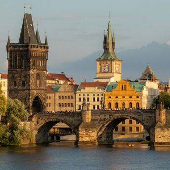 Charles Bridge spanning the Vltava River in Prague with historic towers in the background