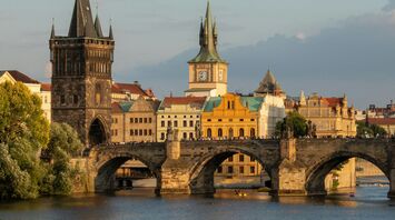 Charles Bridge spanning the Vltava River in Prague with historic towers in the background