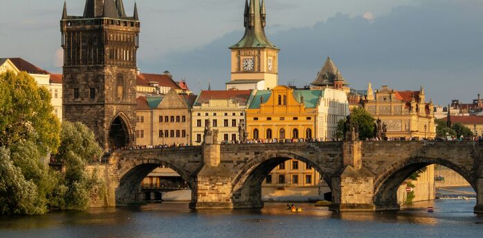 Charles Bridge spanning the Vltava River in Prague with historic towers in the background