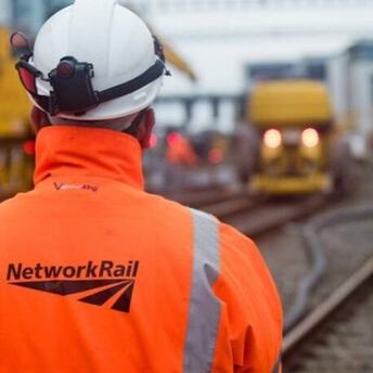 Network Rail engineer standing beside railway tracks