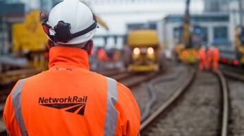 Network Rail engineer standing beside railway tracks