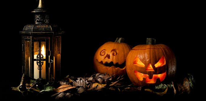Glowing Halloween pumpkins beside lantern