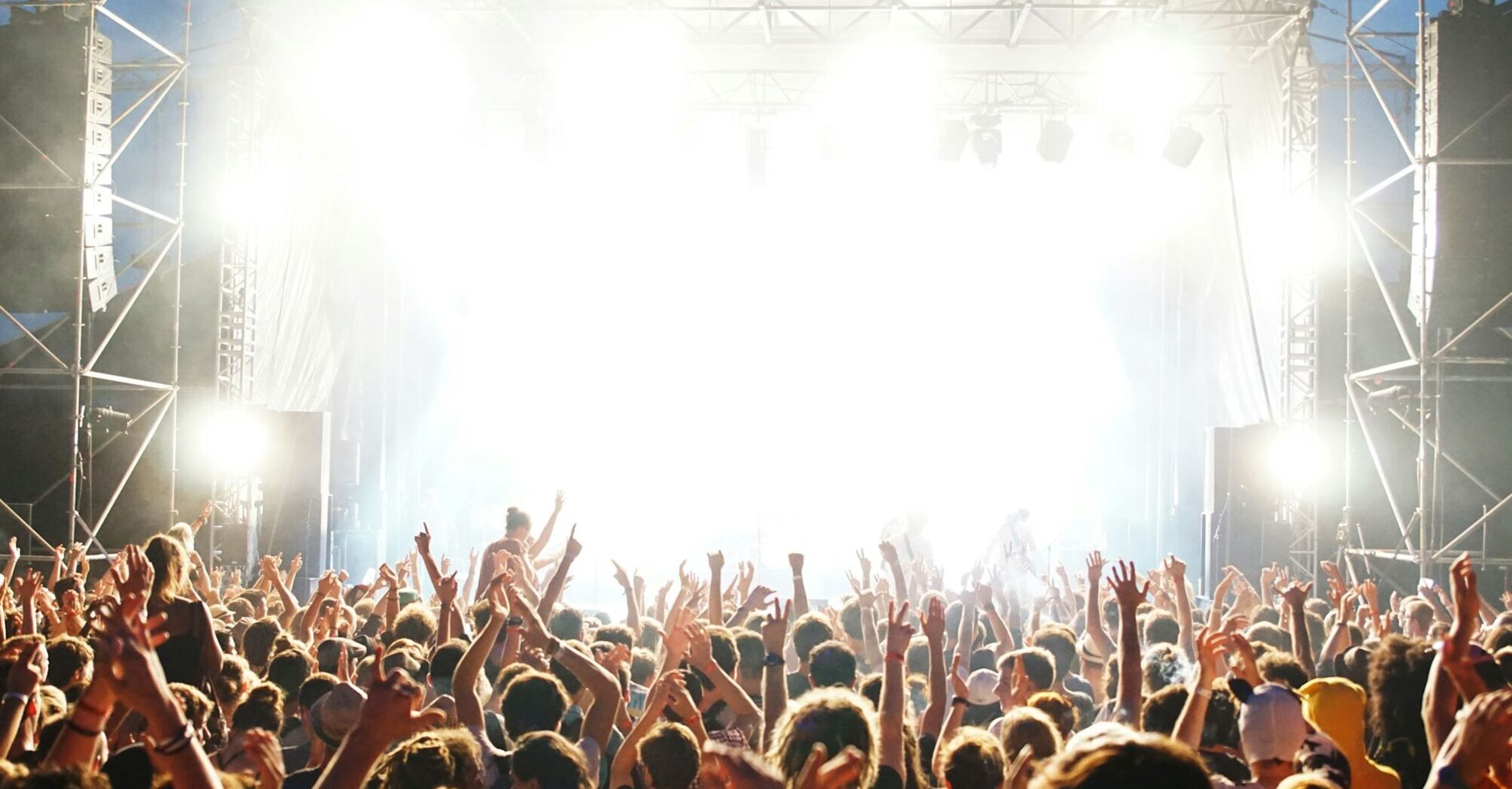 Crowd dancing at an outdoor daytime music event