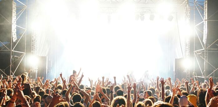 Crowd dancing at an outdoor daytime music event
