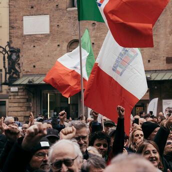 Crowd holding Italian flags during a demonstration
