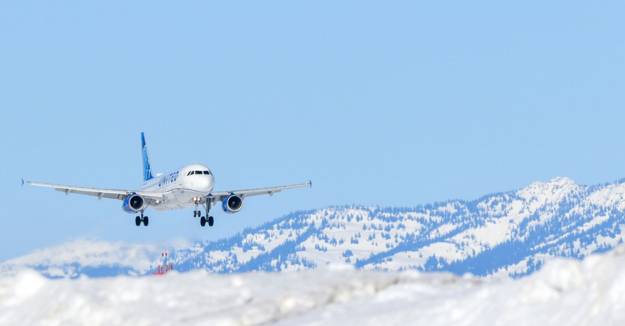 Passenger aircraft approaching a snowy mountain airport