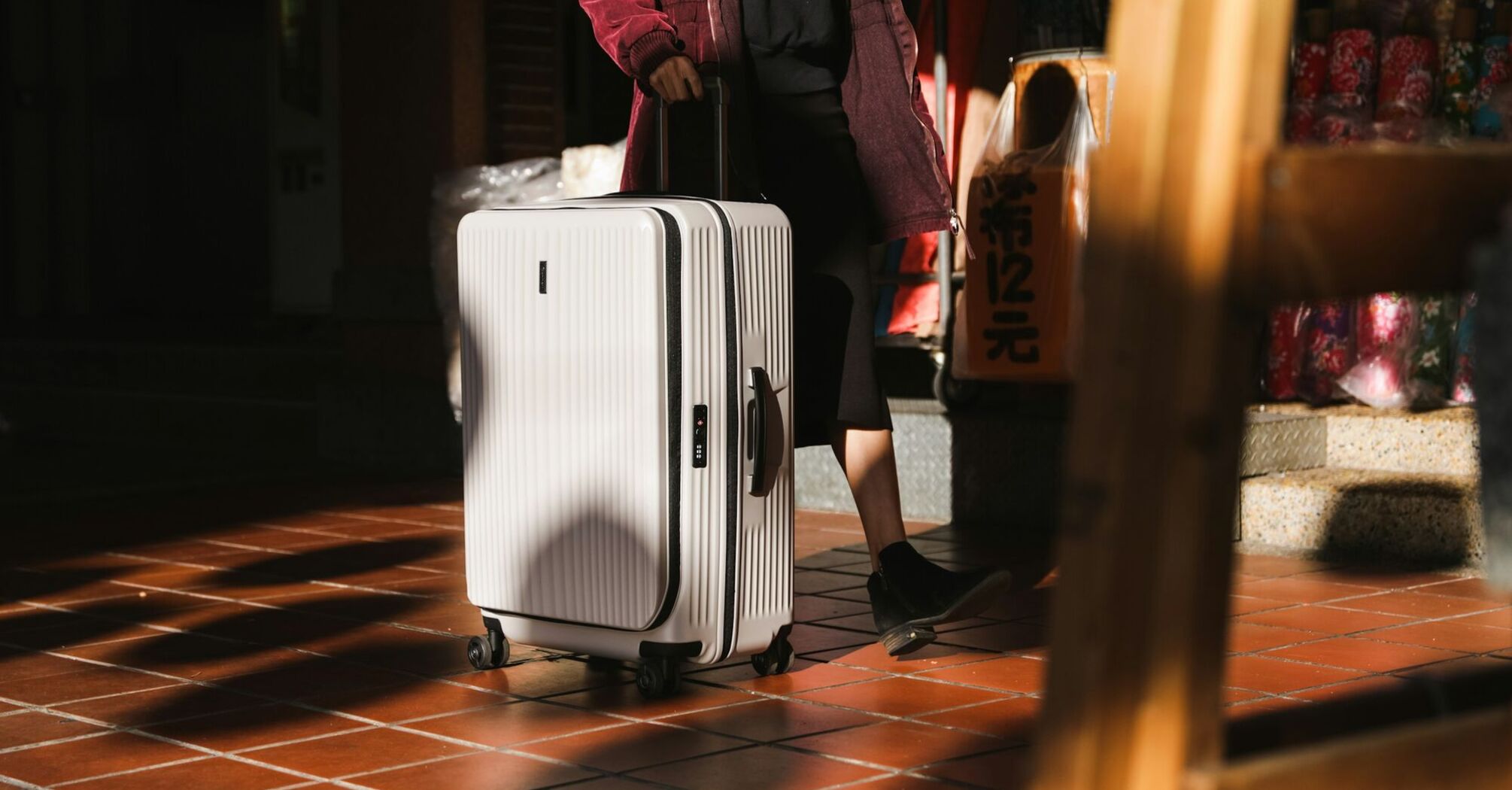 Passenger travelling with a hard-shell suitcase in an urban setting