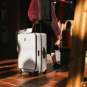 Passenger travelling with a hard-shell suitcase in an urban setting