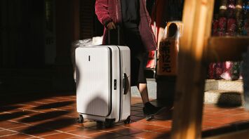 Passenger travelling with a hard-shell suitcase in an urban setting