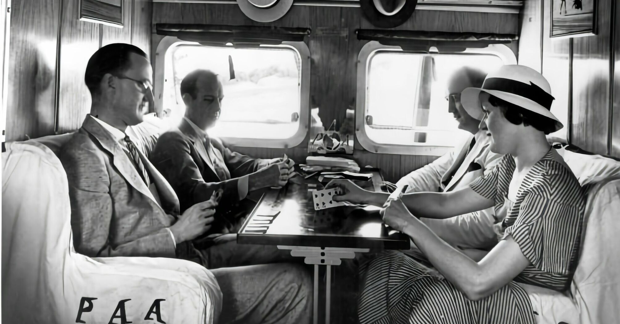 Passengers socialising inside a vintage railway carriage in the 1930s