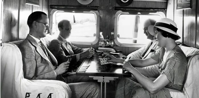 Passengers socialising inside a vintage railway carriage in the 1930s