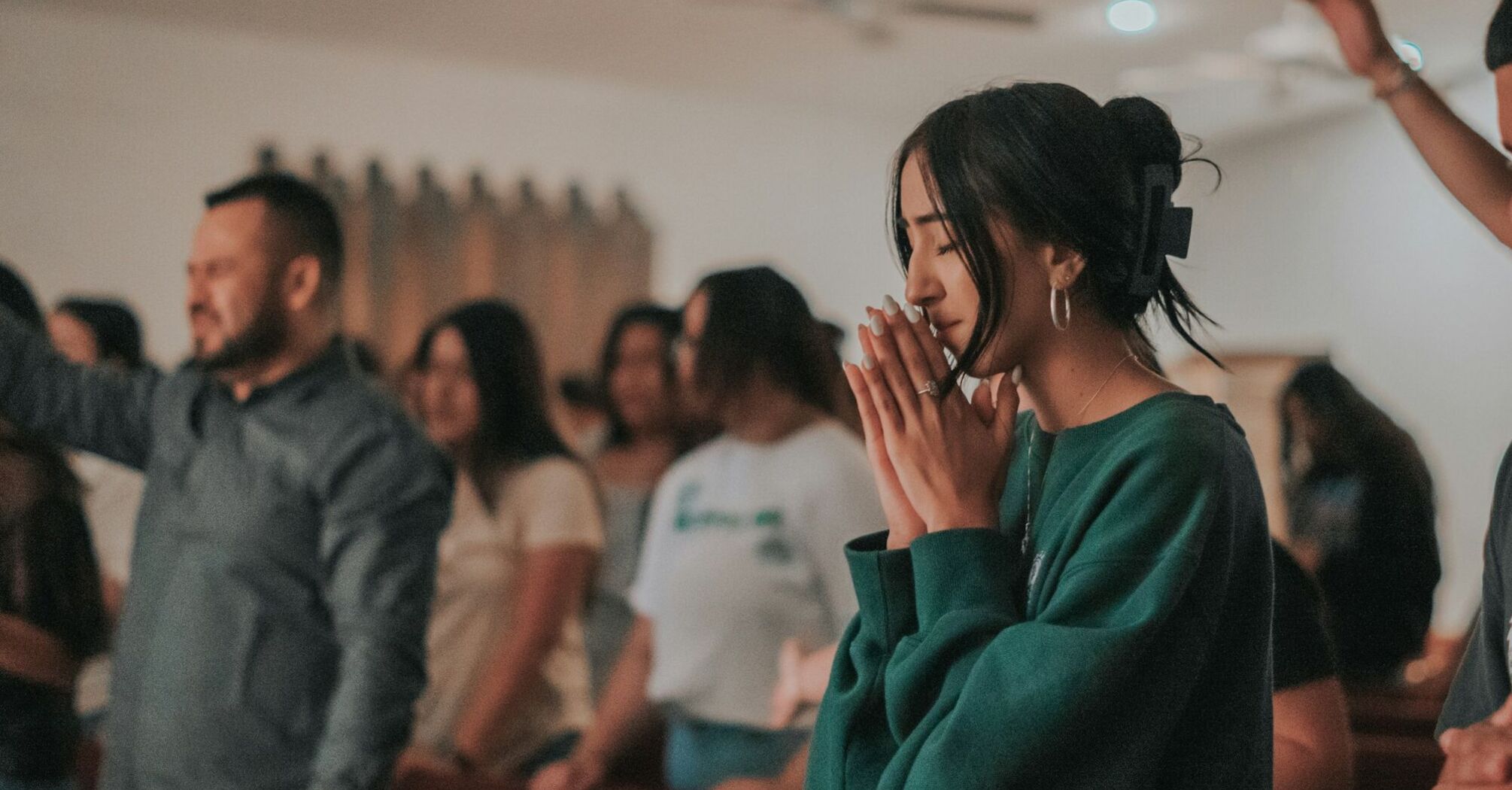 People taking part in a quiet prayer gathering indoors
