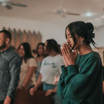 People taking part in a quiet prayer gathering indoors