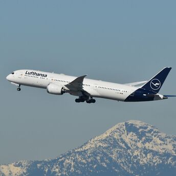 Lufthansa passenger aircraft flying above mountainous terrain