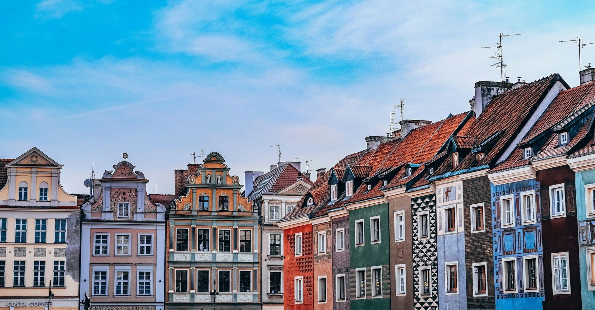 Colourful townhouses in Poznań Old Town under blue sky