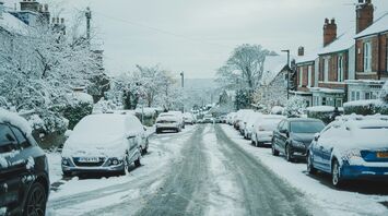 Snow-covered residential street with icy road conditions