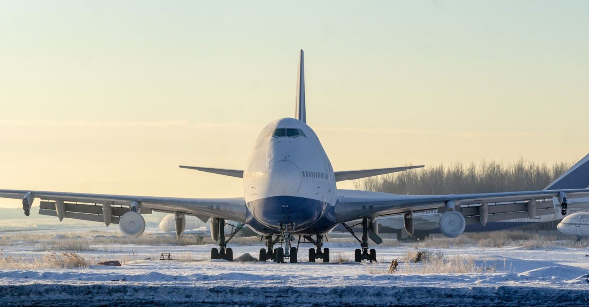 Large aircraft taxiing on snow-covered runway during winter conditions
