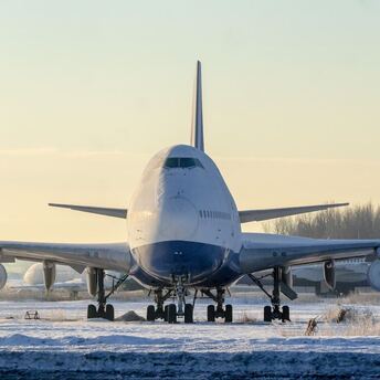 Large aircraft taxiing on snow-covered runway during winter conditions