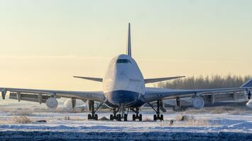 Large aircraft taxiing on snow-covered runway during winter conditions