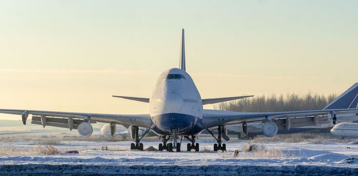 Large aircraft taxiing on snow-covered runway during winter conditions