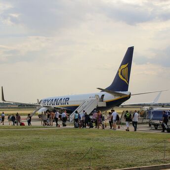 Ryanair aircraft boarding passengers via mobile stairs at a regional airport