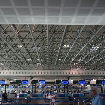 Airport check-in hall with passengers queueing during peak hours
